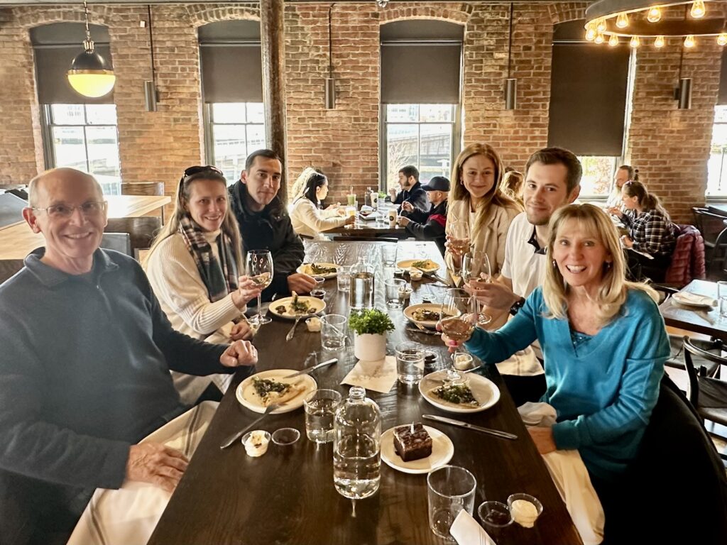 A group raises their glasses to toast at a table full of food in Providence, Rhode Island. 